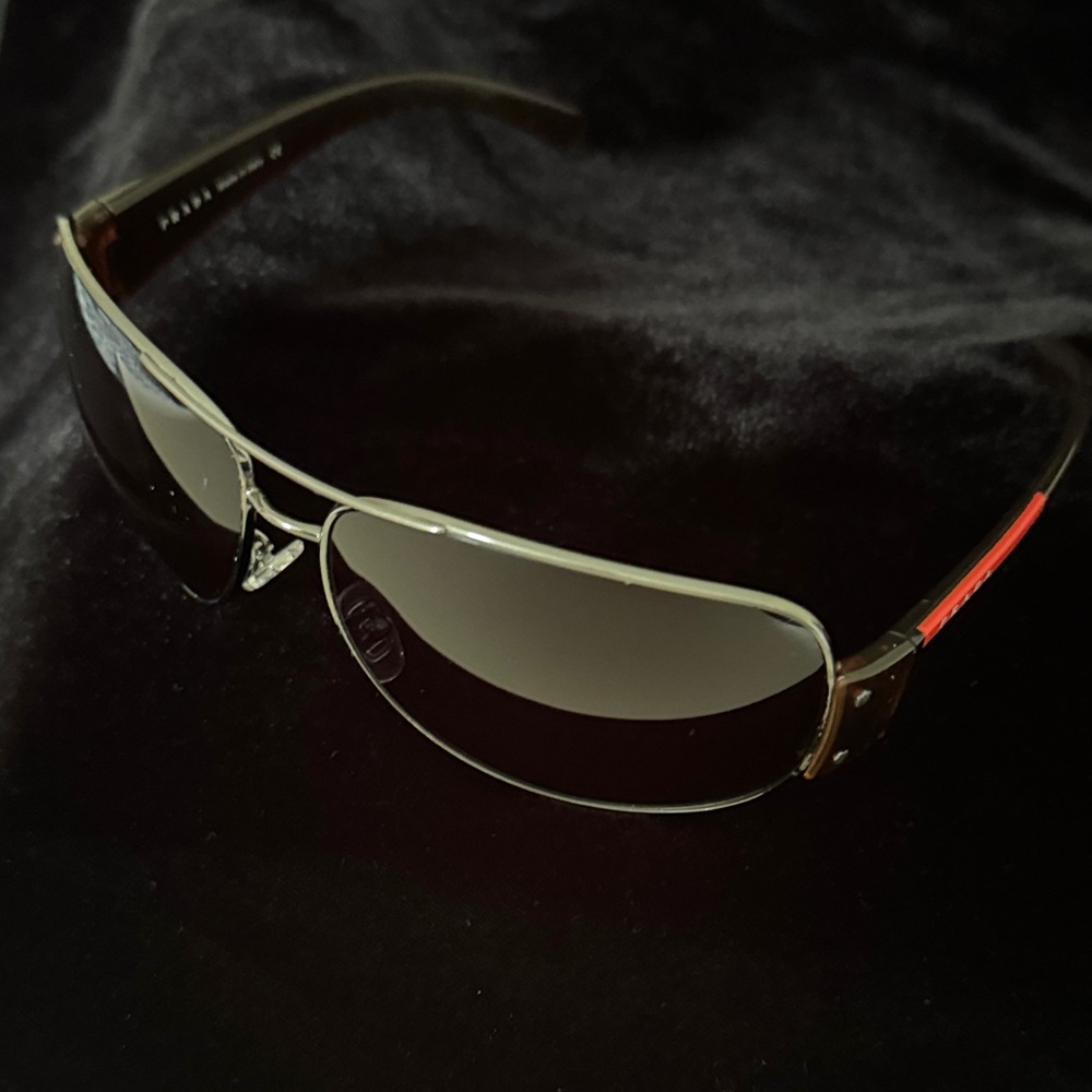 Prada Men’s Silver Frame Black Gradient Lens Sunglasses with Red Accent
